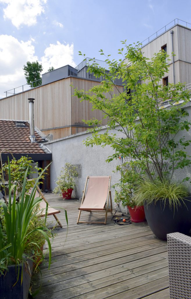 Photo d'une cour aménagée avec terrasse en bois et végétaux, réalisée par Atelier DLV, architecte extérieur maison